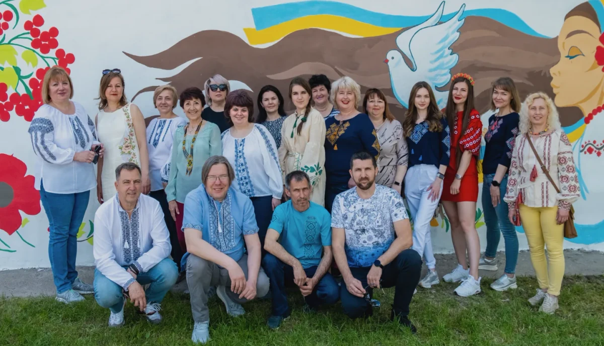 Команда фонду «Руки друзів» у вишиванках біля муралу з голубом миру